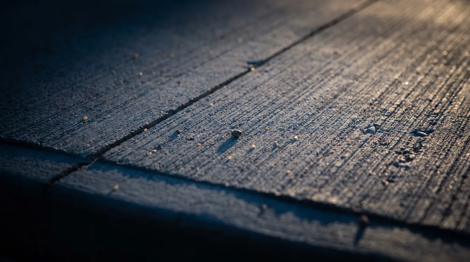 Close view of a broom finished concrete surface and a tooled control joint